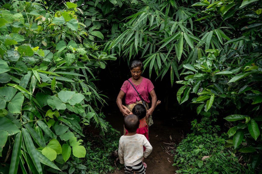 After fleeing military attacks, a woman and her grandchildren seek shelter in a bamboo grove in the forest.